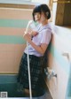 A woman in a school uniform is taking a shower.