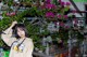 A woman standing in front of a bunch of flowers.