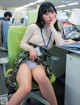 A woman sitting on a green chair in an office.