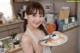 A woman holding a plate of food in a kitchen.