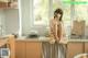 A woman sitting on top of a kitchen counter.