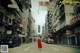 A woman in a red dress walking down a street.