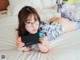 A woman laying on a bed holding a Nintendo Switch.