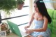 A woman sitting on a green couch using a laptop computer.